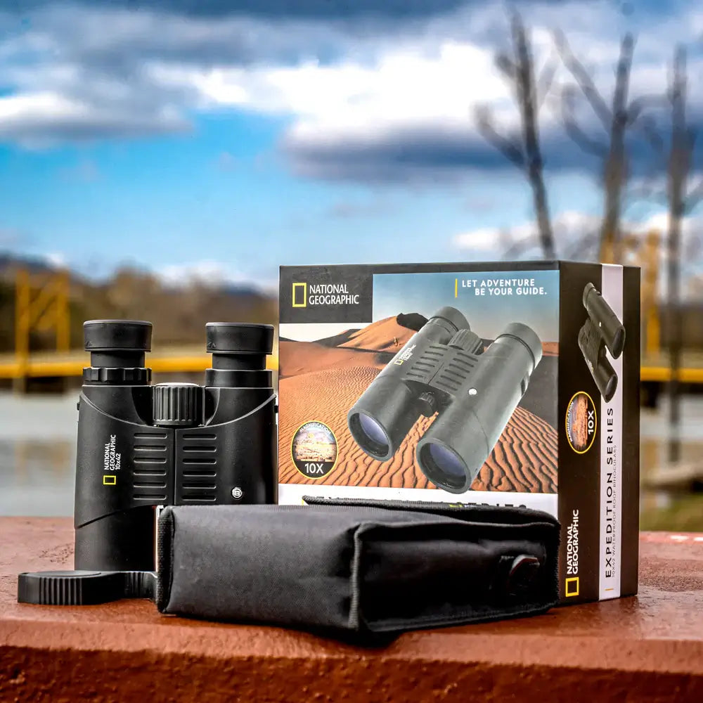 National Geographic binoculars with packaging on a wooden surface with a scenic background