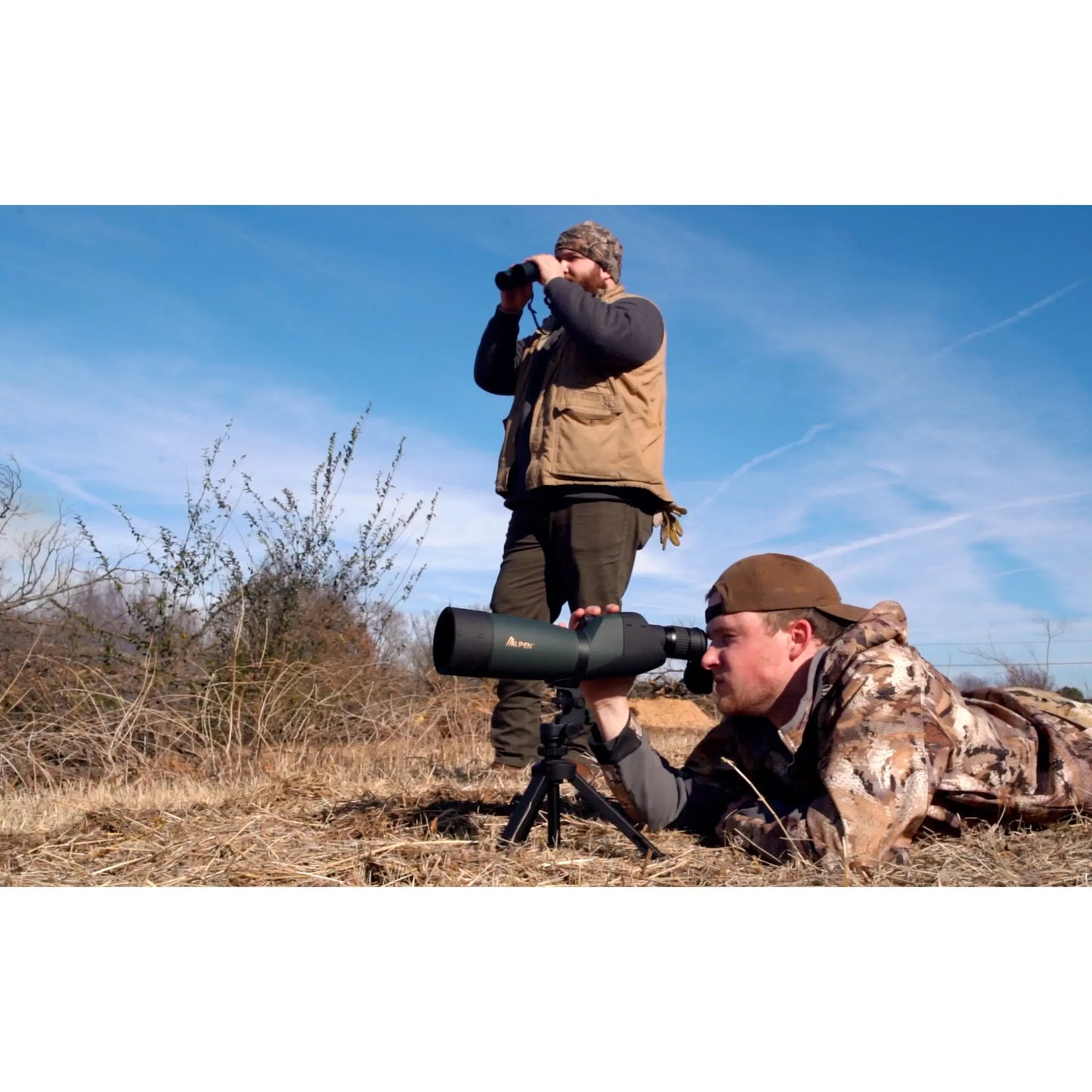 Adult male using the Alpen Shasta Ridge 20-60x80 Waterproof Spotting Scope in a grassy area.