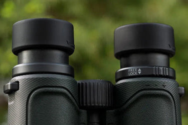 Close-up of a pair of binoculars with a blurred green background
