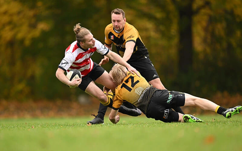 Rugby players in action on a grass field with a blurred background