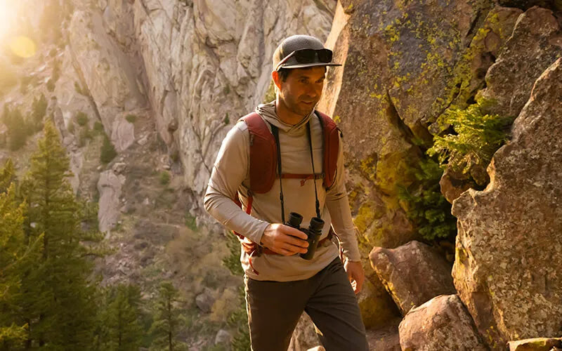 Man hiking in a mountainous area with binoculars