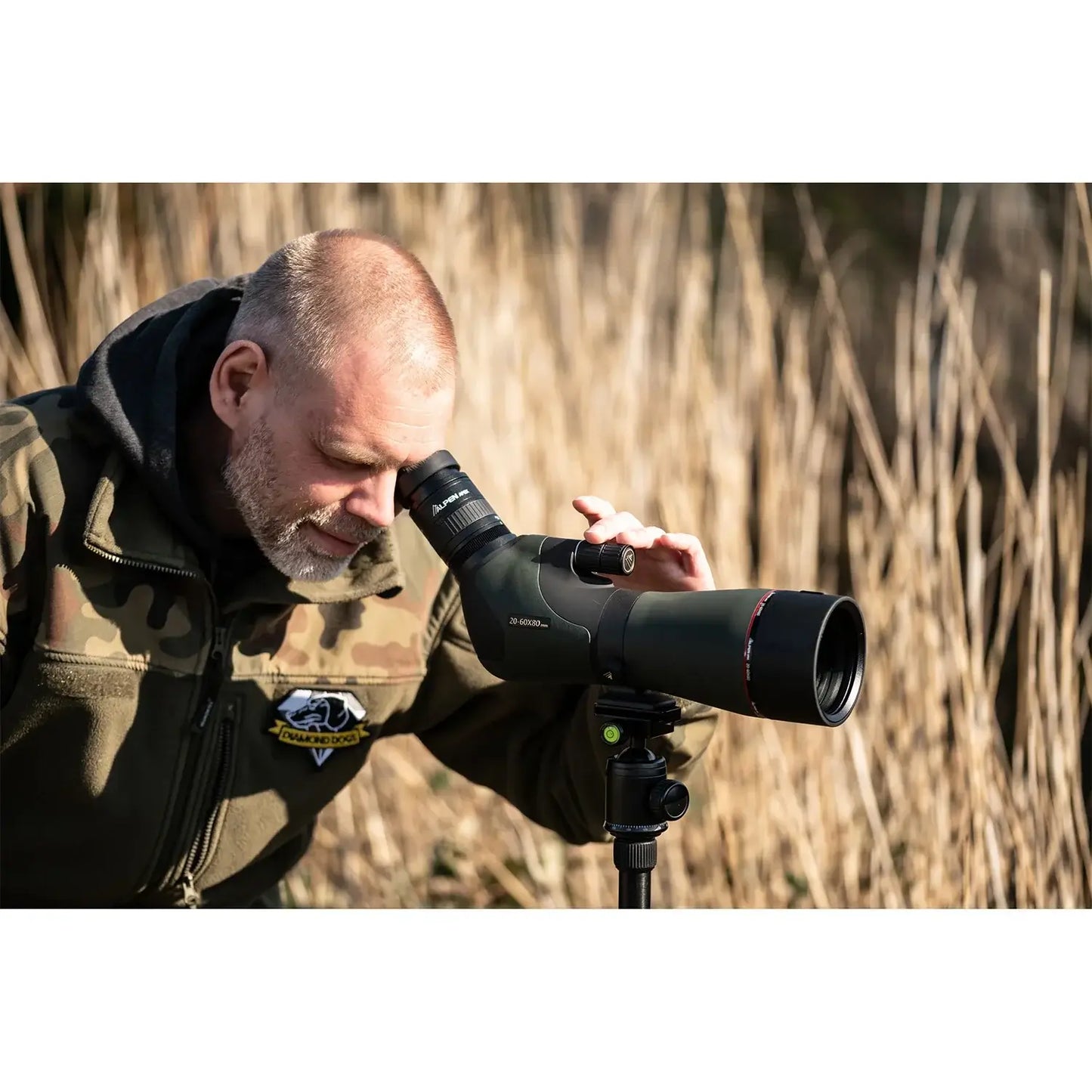 Man using the tripod mounted Alpen Apex XP ED Waterproof Spotting Scope.