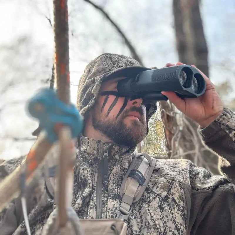 Man using Alpen Apex Steady 14x42 HD Binoculars with Image Stabilization in a natural setting.