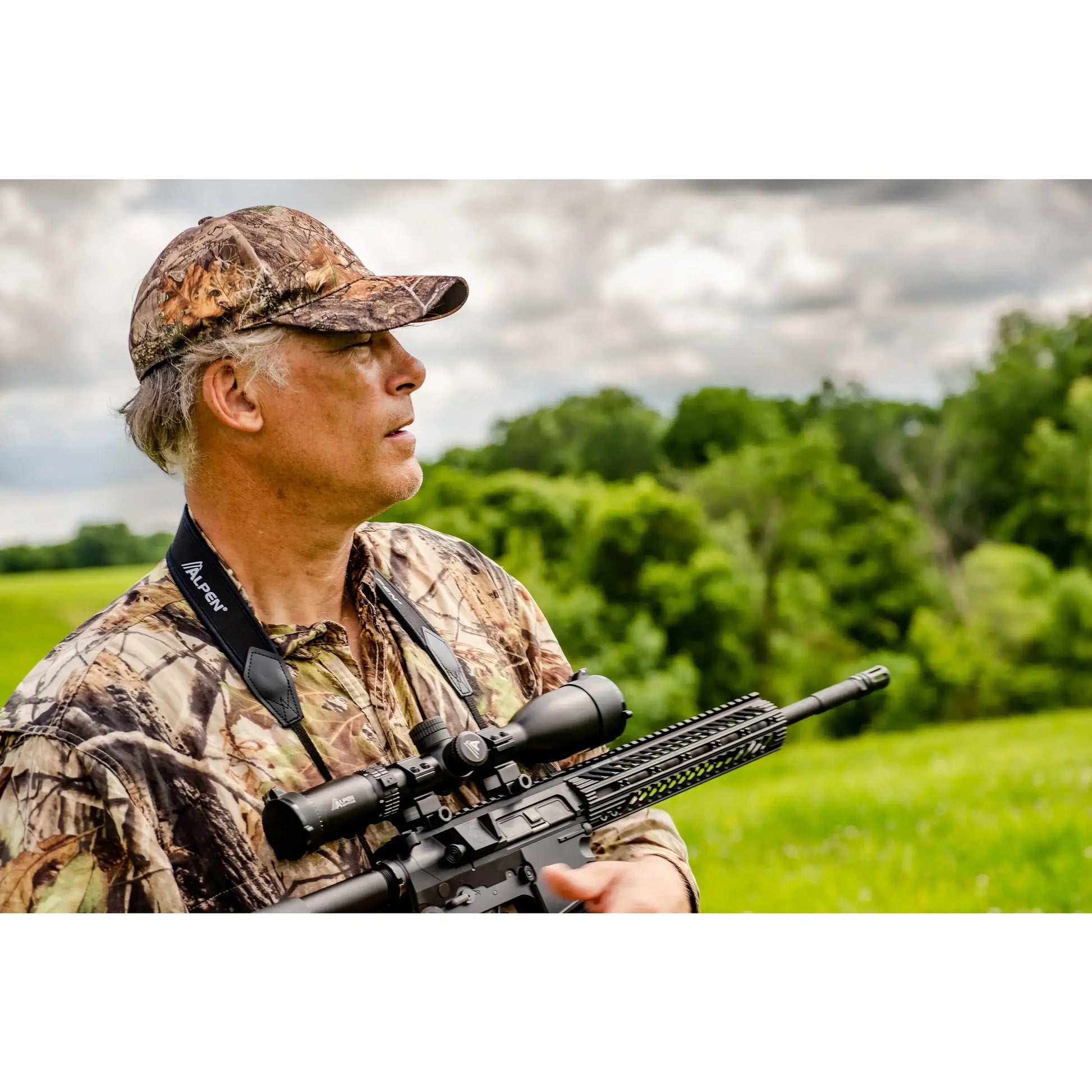 man in camo holding a rifle with an Alpen Riflescope mounted. 