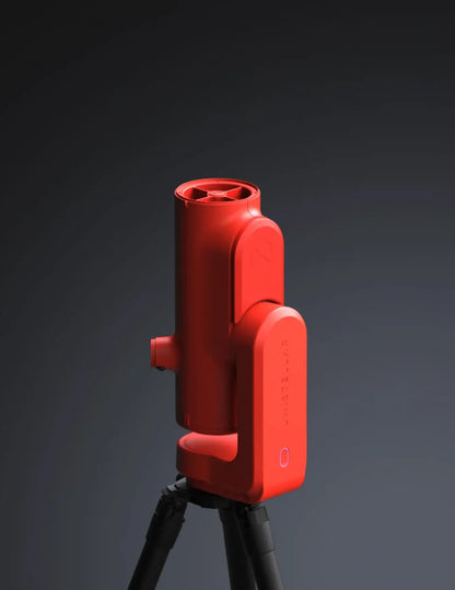 Red laser level on a black tripod against a dark background