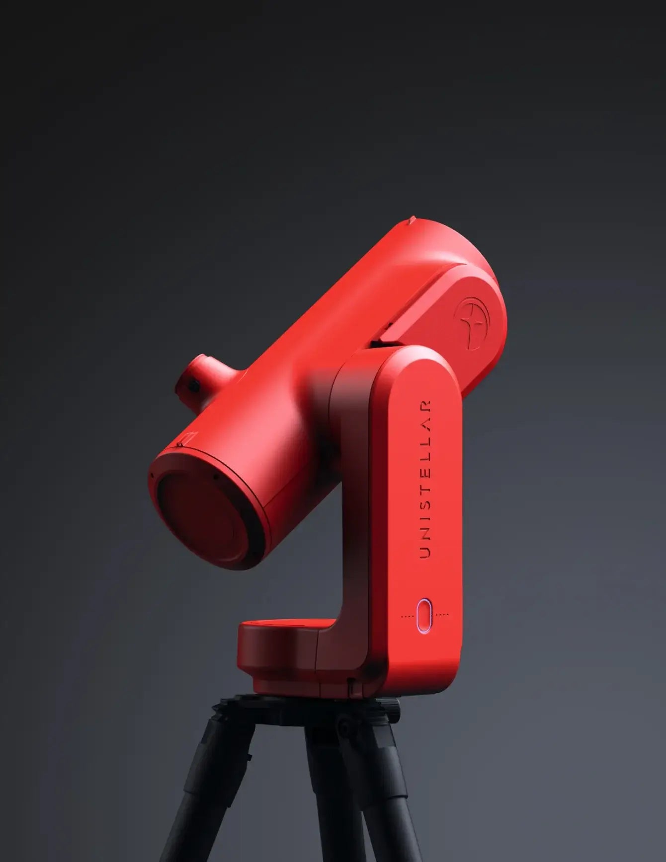 Red telescope on a stand against a dark background