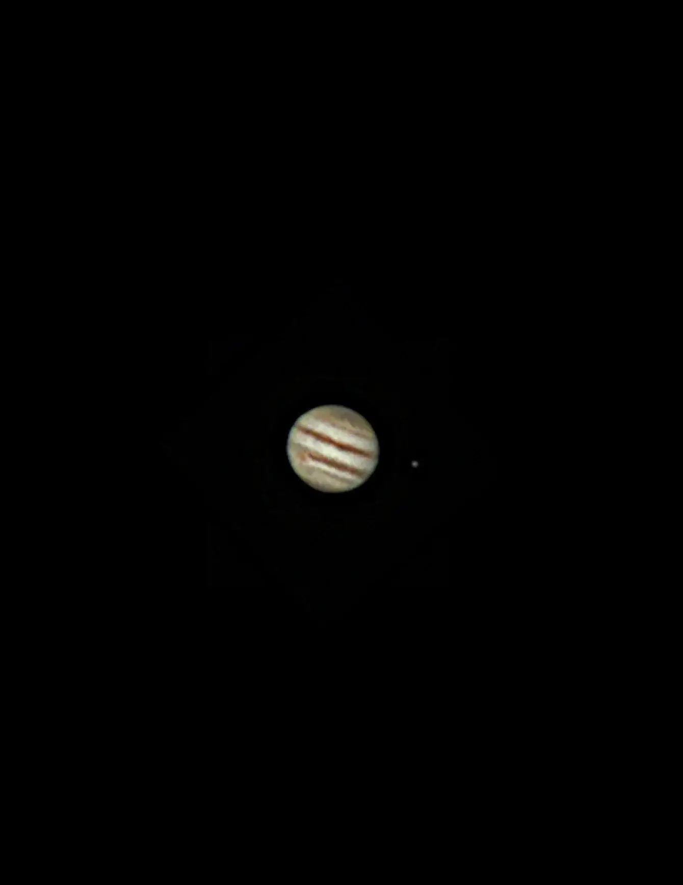Jupiter with its moon Io in the foreground on a black background