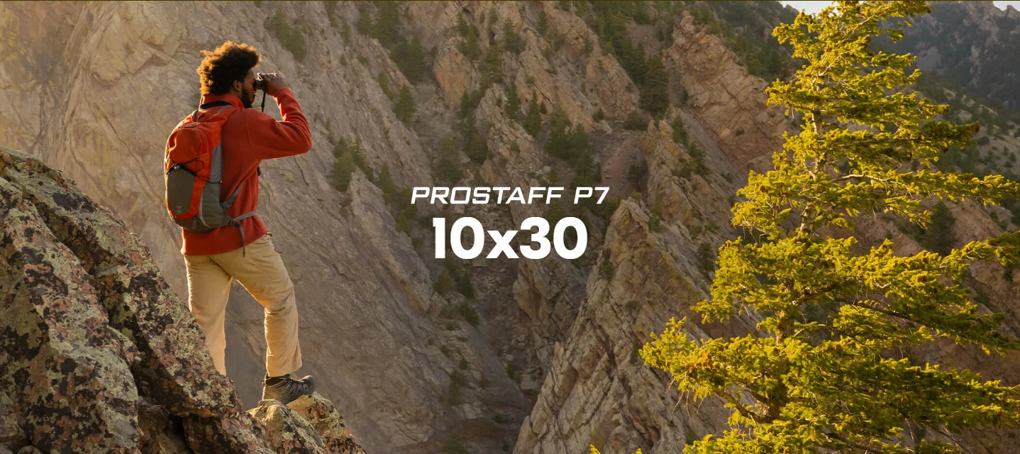 Person on a mountain peak using binoculars with 'Prostaff P7 10x30' text overlay