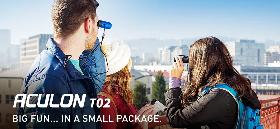 Two people taking photos with binoculars and a camera, with 'ACULON T02' branding.