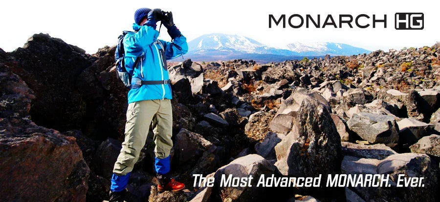 Serious hiker using Nikon Monarch HG binoculars to view terrain in the distance.